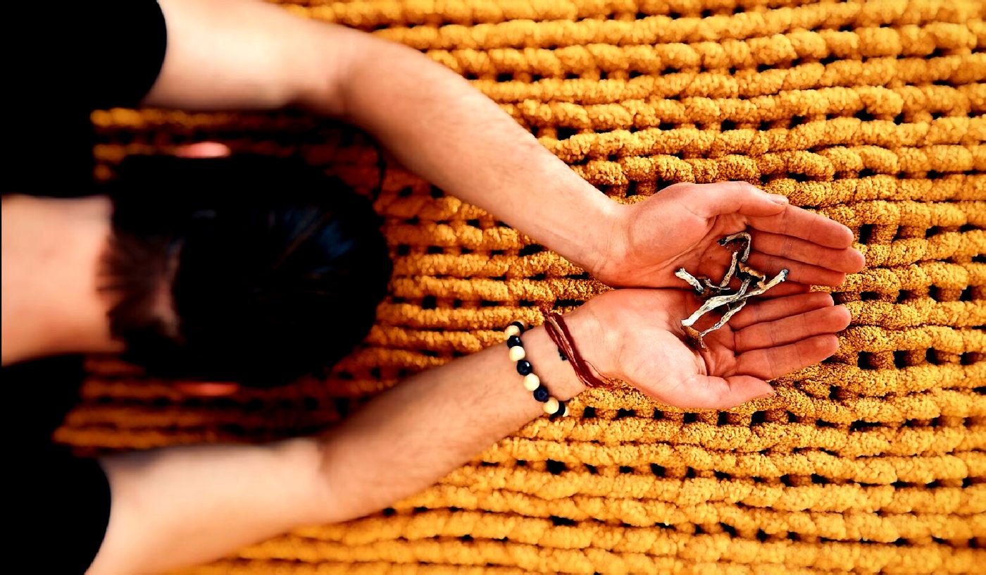 Open hands resting on a woven mat