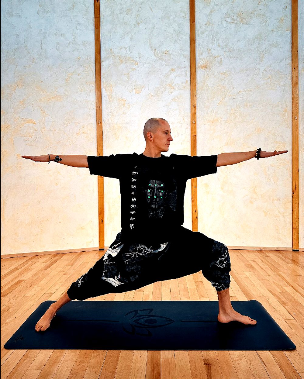 Pasha in warrior pose on a yoga mat